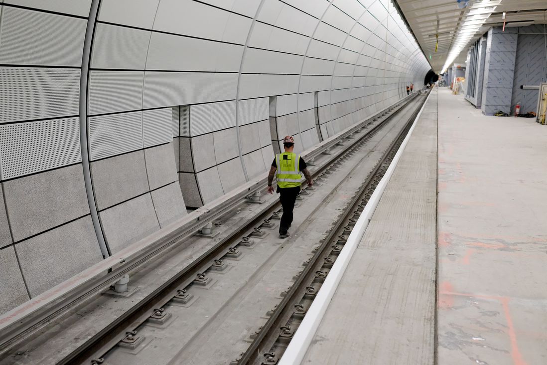 A long tunnel, with a worker walking on the tracks, is seen.